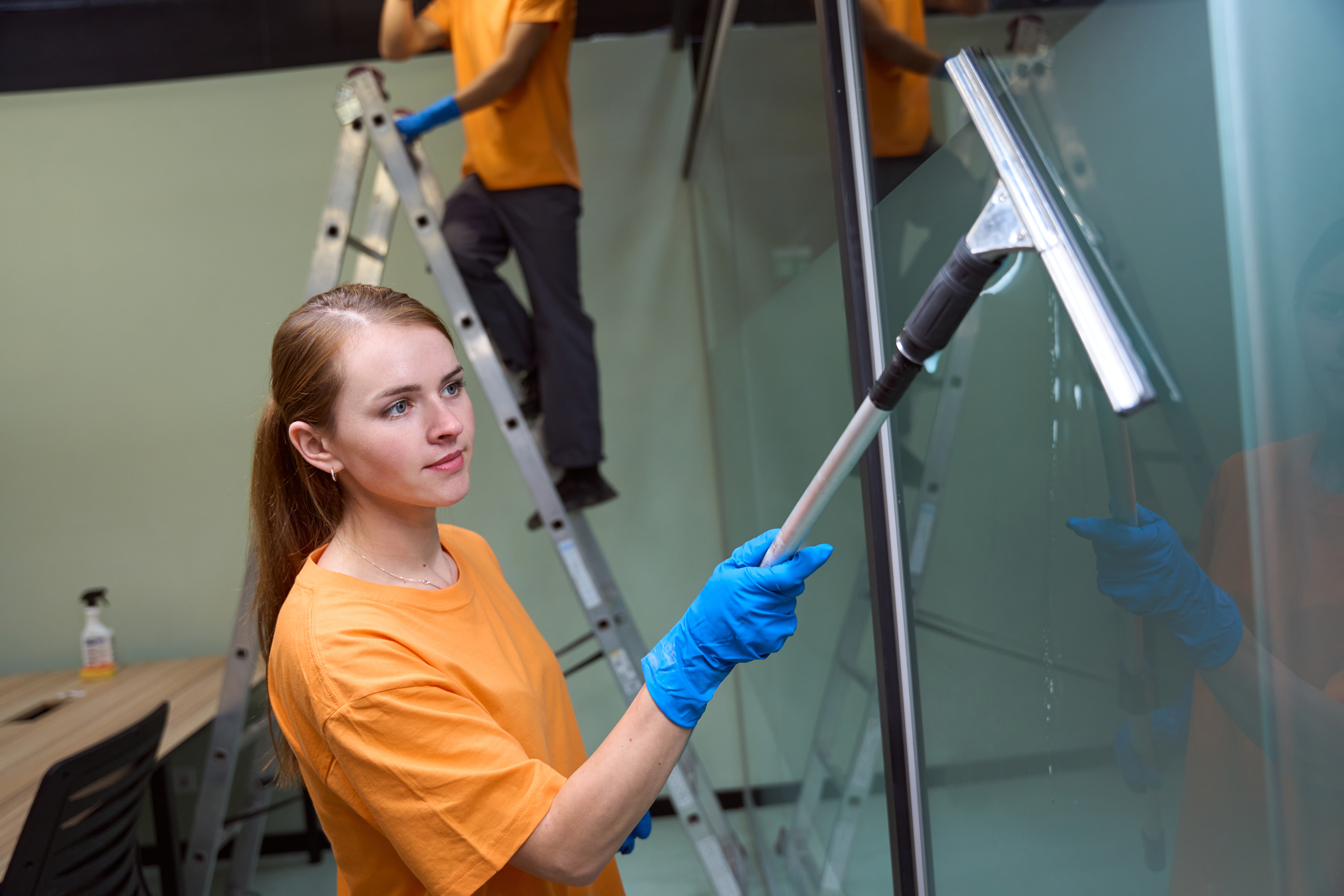 Certified janitor is performing window-cleaning procedure professionally